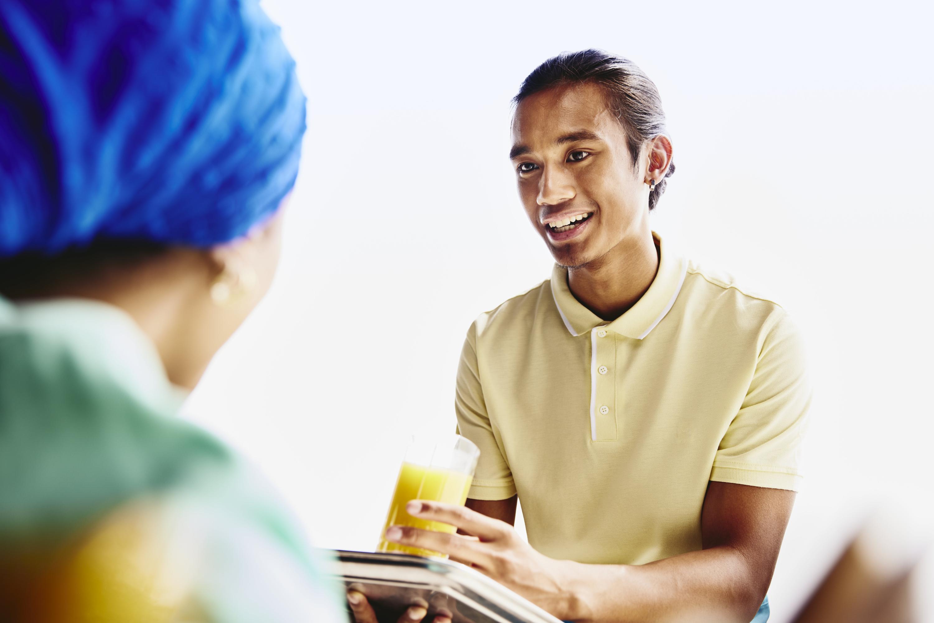 Waiter serving a drink to a woman.