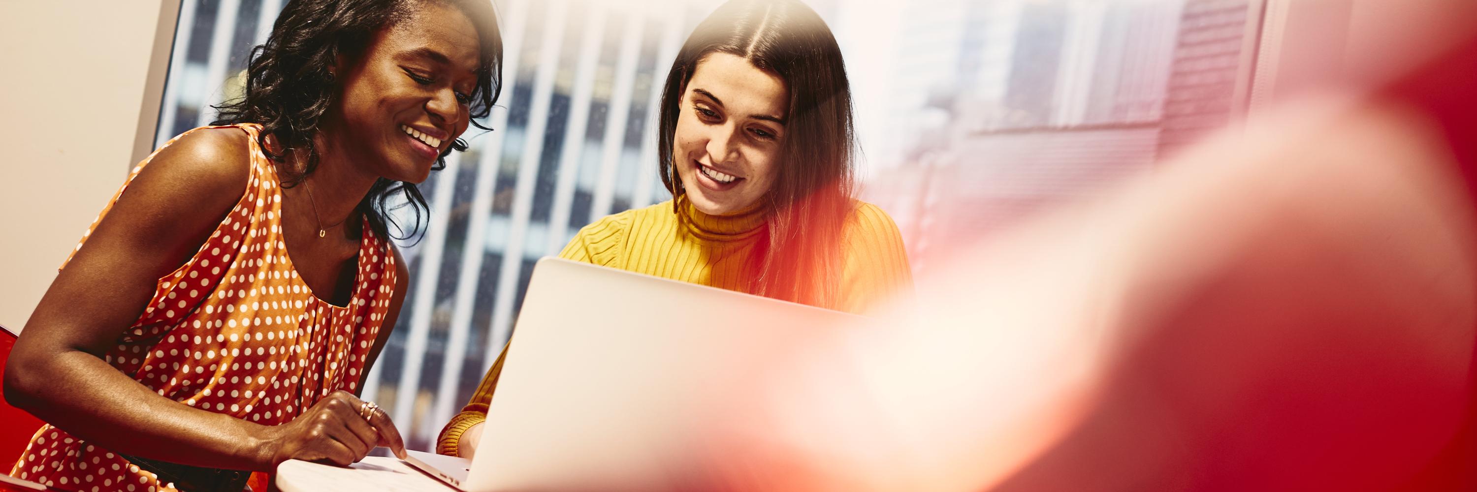 Two smiling women working together