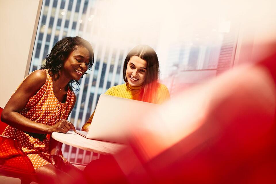 2 women behind a laptop