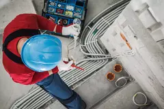 Top view of electrician checking wires while performing electrical wiring installation.