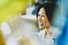 Older woman smiling. Japan. Primary color: yellow.