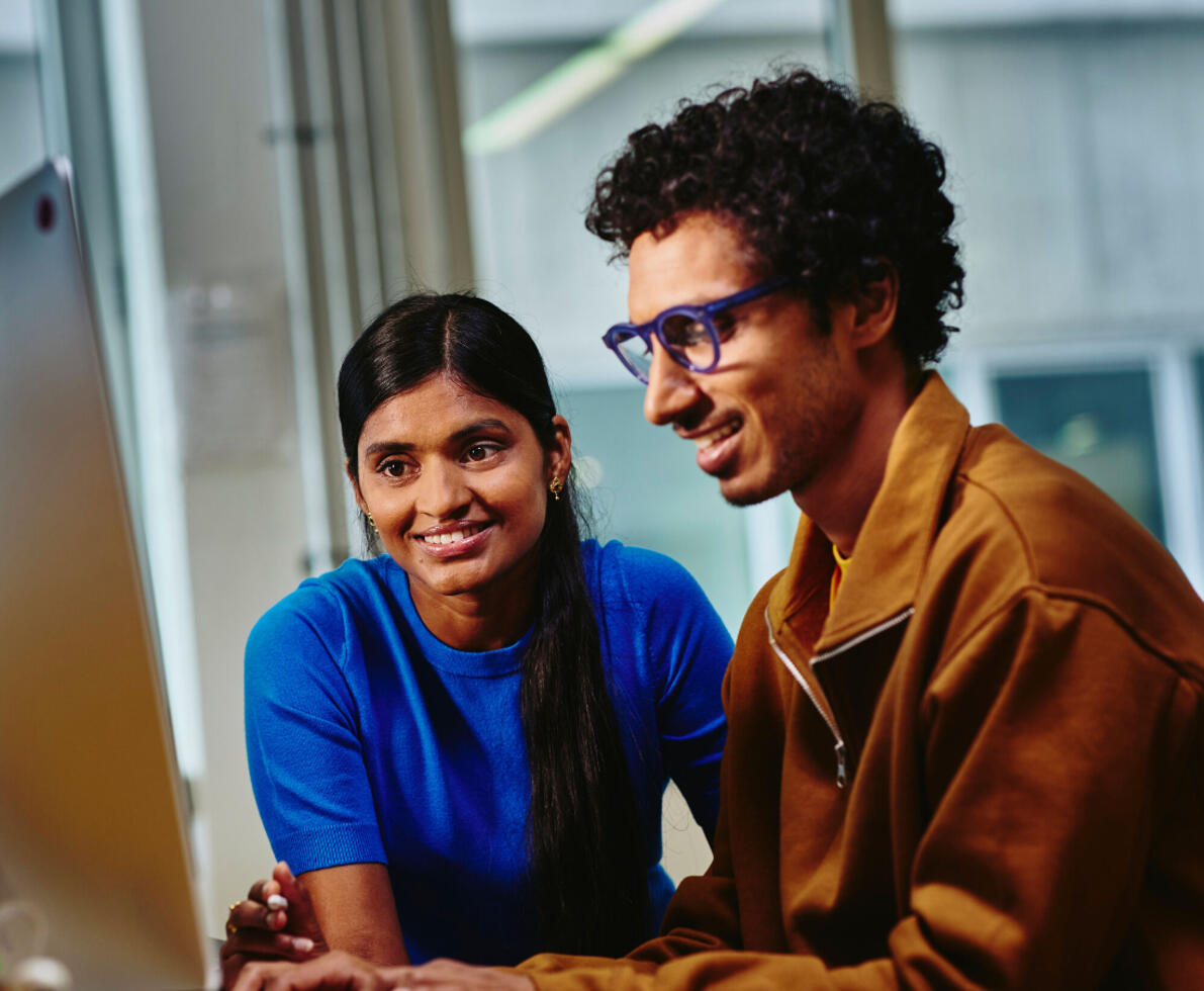 man typing while woman watch the screen